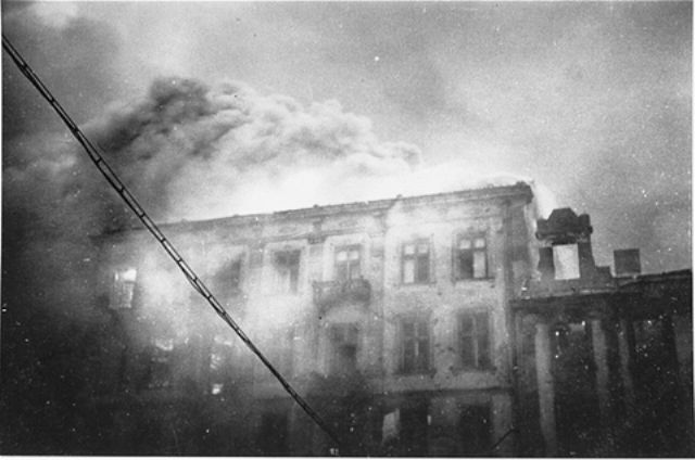 An apartment building razed by the SS burns during the suppression of the Warsaw ghetto uprising